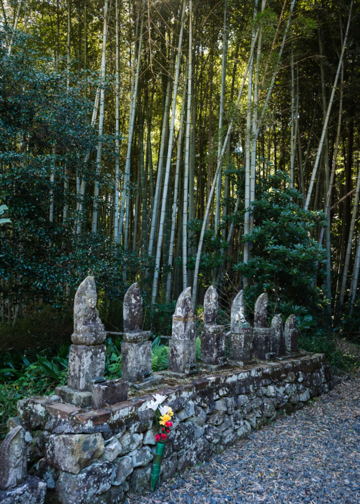statues de pierre devant un bosquet de bambou au Japon