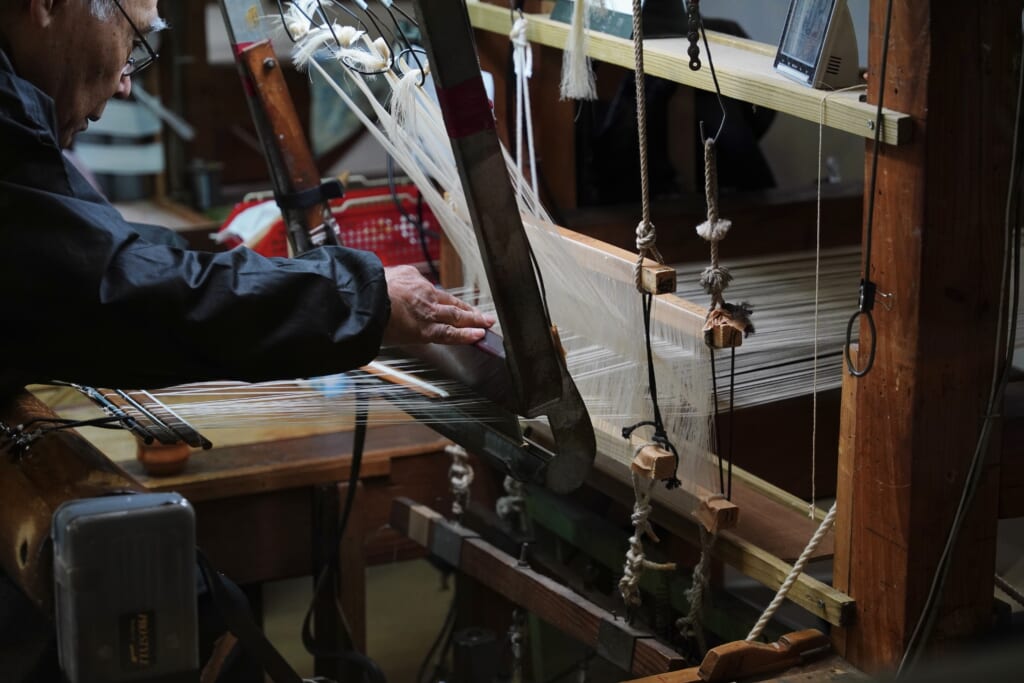un artisan japonais travaillant sur un métier à tisser