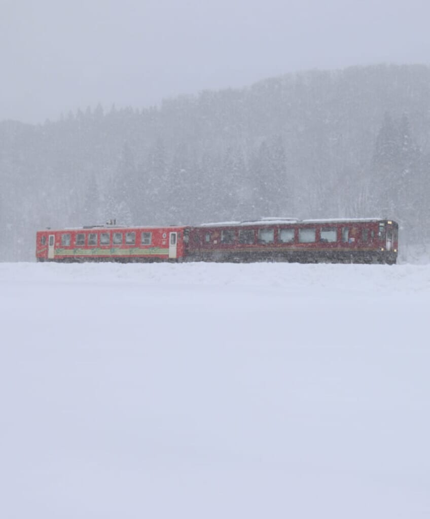 les wagons rouges d'un train sous la neige au Japon, à Semboku