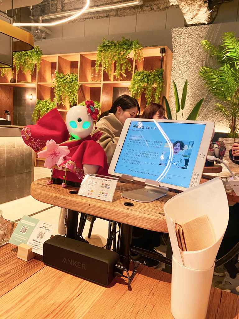 Une tablette sur la table d'un café japonais qui permet de discuter avec les employés travaillant à distance