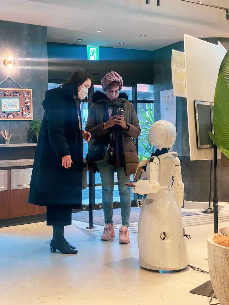 Les clients d'un café japonais face au robot qui les accueille