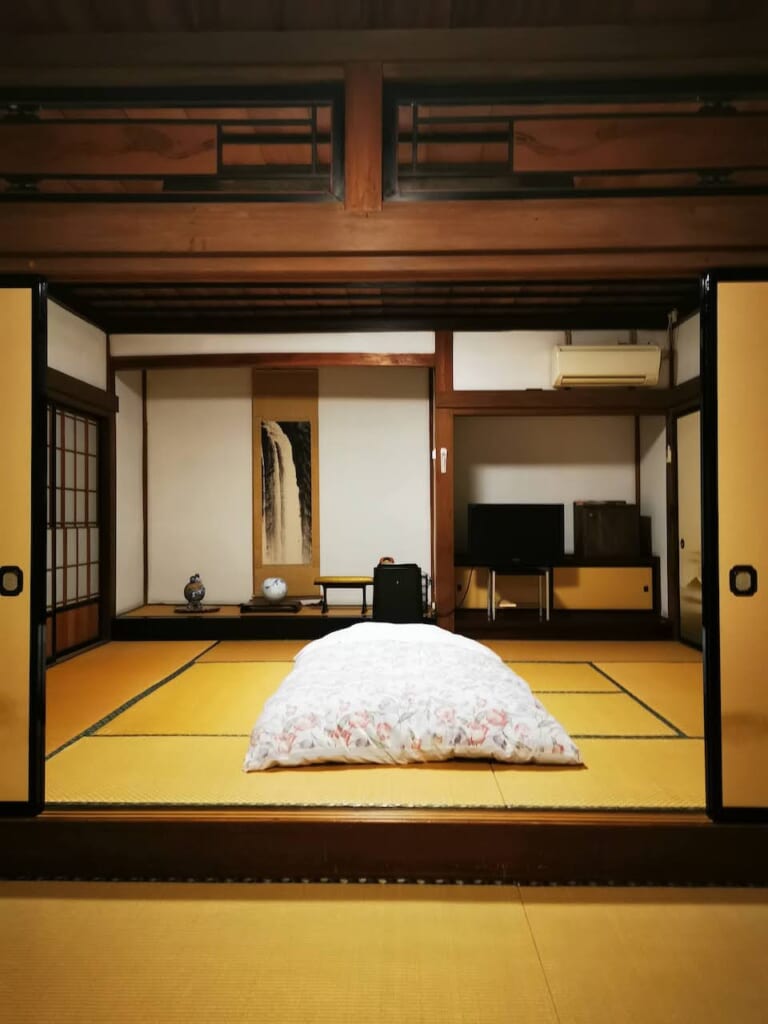 chambre d'auberge japonaise avec sol en tatami et lit futon
