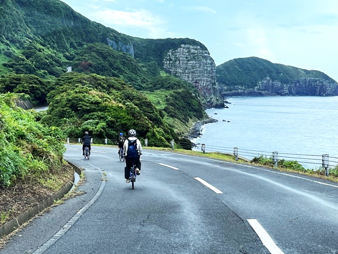 Trois cyclistes sur une route cotiere au japon
