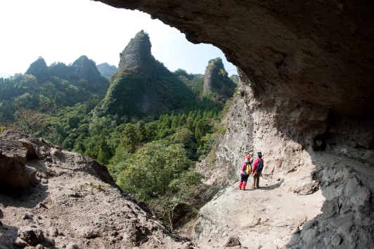 Deux personnes dans une grotte naturelle face à un paysage incroyable au Japon, sur l'île de Kyushu