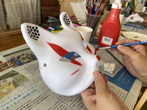 Un masque de renard traditionnel en train d'être peint au Japon