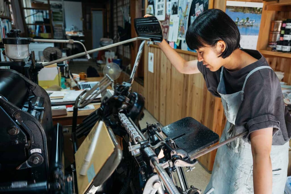 Une femme opère une presse Heidelberg Platen sur l'île d'Ojika à Nagasaki