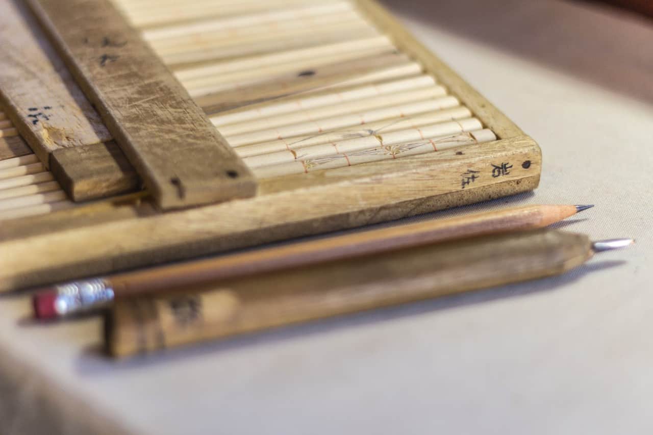 Un lapiz y una herramienta para tallar madera