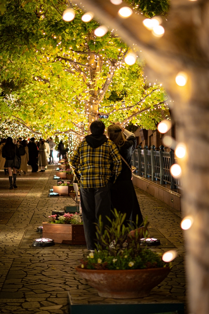 Una pareja tomándose una foto en las iluminaciones de invierno