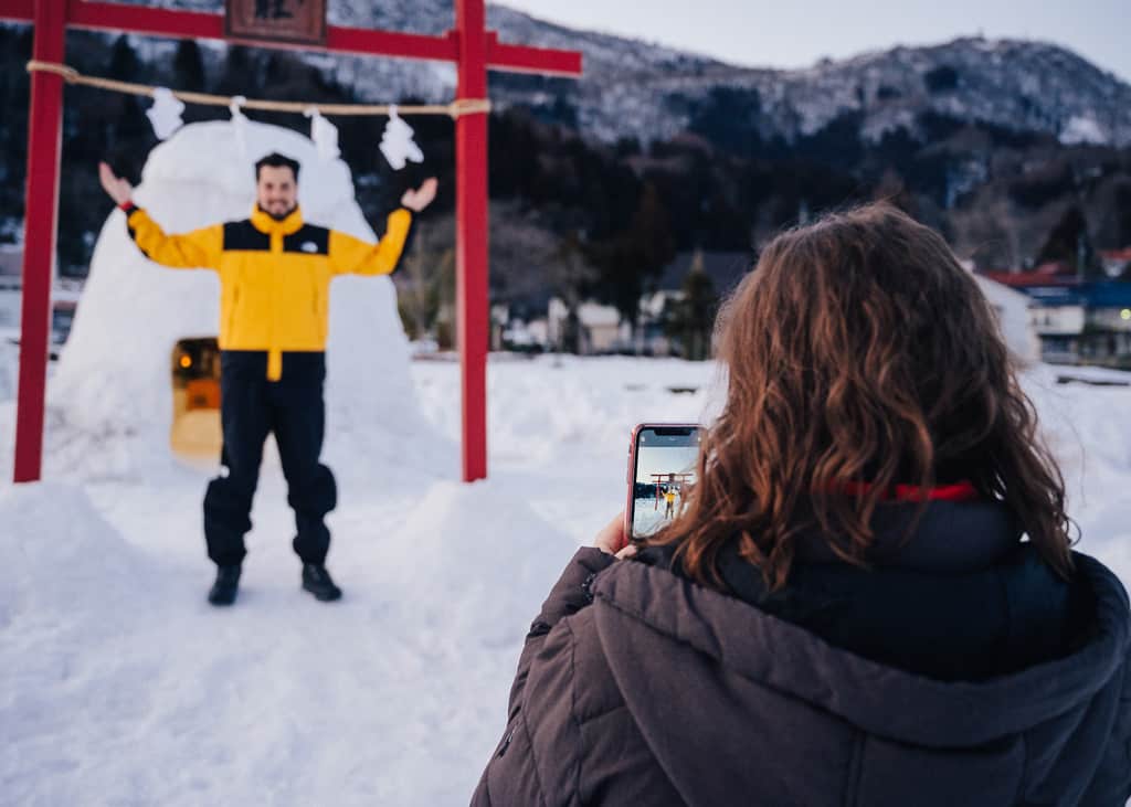 Maria y Hernán sacándose fotos delante del santuario de nieve en Iiyama