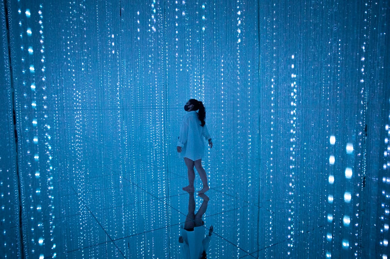chica caminando maravillada entre cristales de luz azules