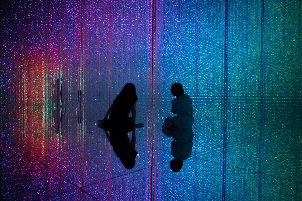 dos chicas sentadas entre cristales de color arcoíris