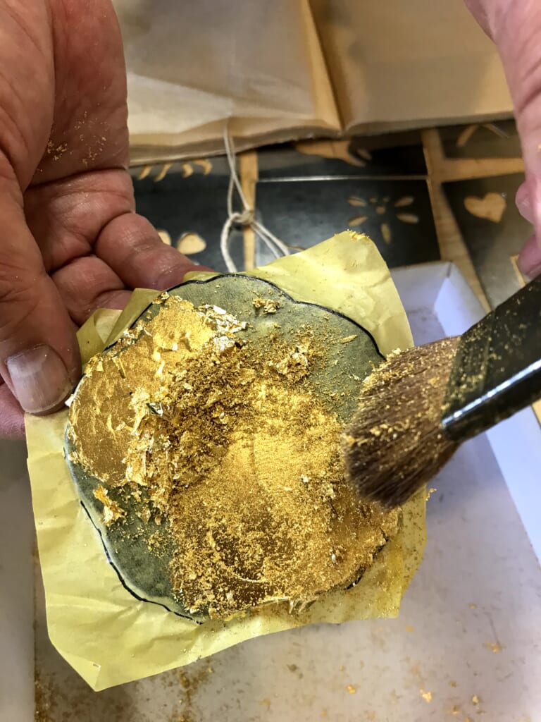 Aplicación de polvo de oro sobre el pan de oro
