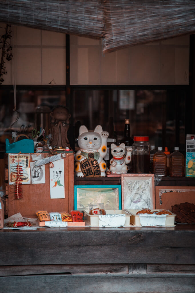 fachada de una tienda de ouchi juku con gatos de la suerte y otros souvenirs