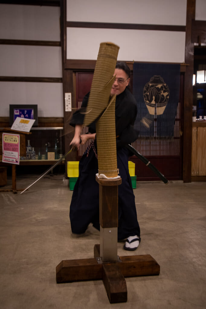 hombre cortando con una katana un tatami enrollado 