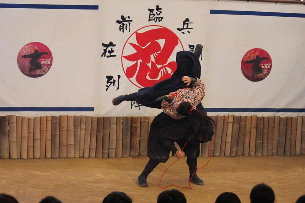 Los actores representando a ninjas mientras hacen acrobacias