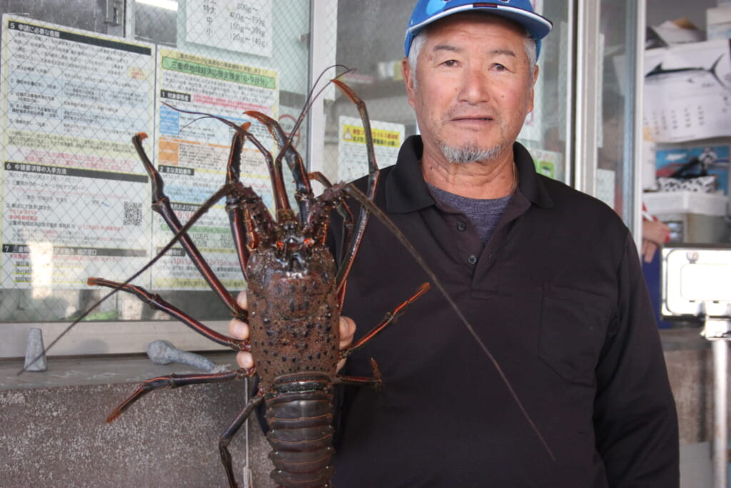 un pescador japonés con un cangrejo de rio