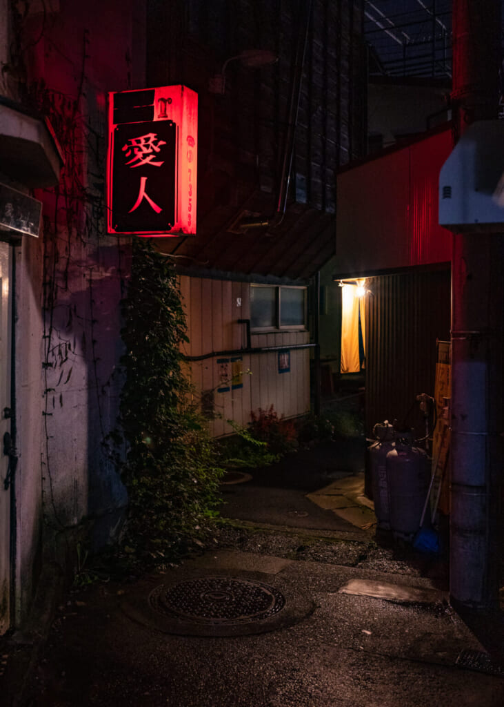 un cartel de neón en una calle oscura japonesa