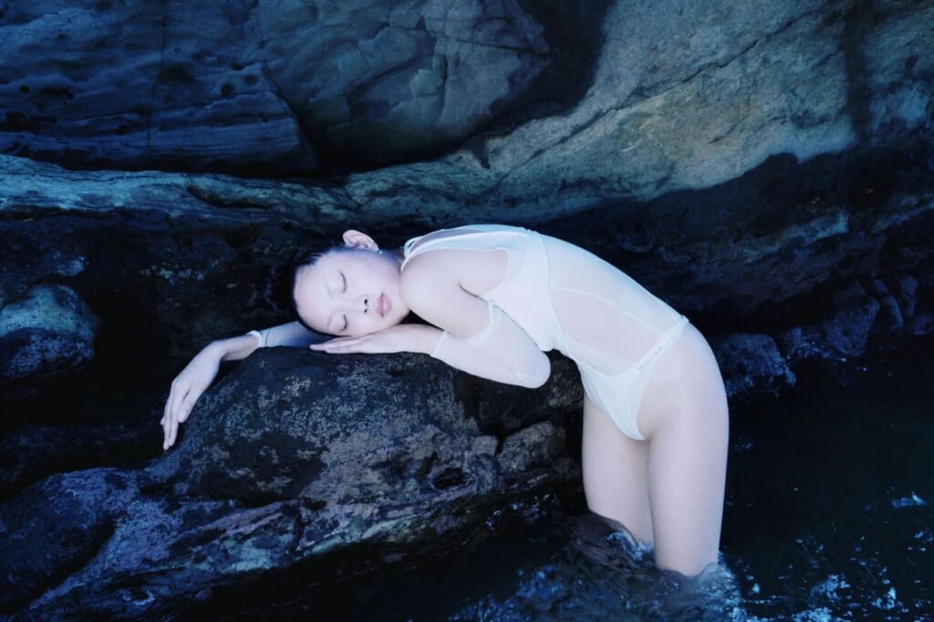 Bailarina de Butoh descansando en la roca de un acantilado