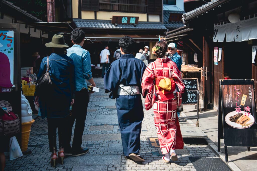 Una pareja con kimono paseando por una calle tradicional japonesa