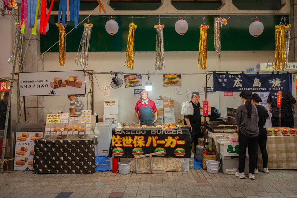 un vendedor sonriendo en un puesto de comida