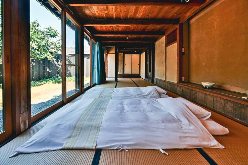 Una habitación con futones encima de un tatami japonés