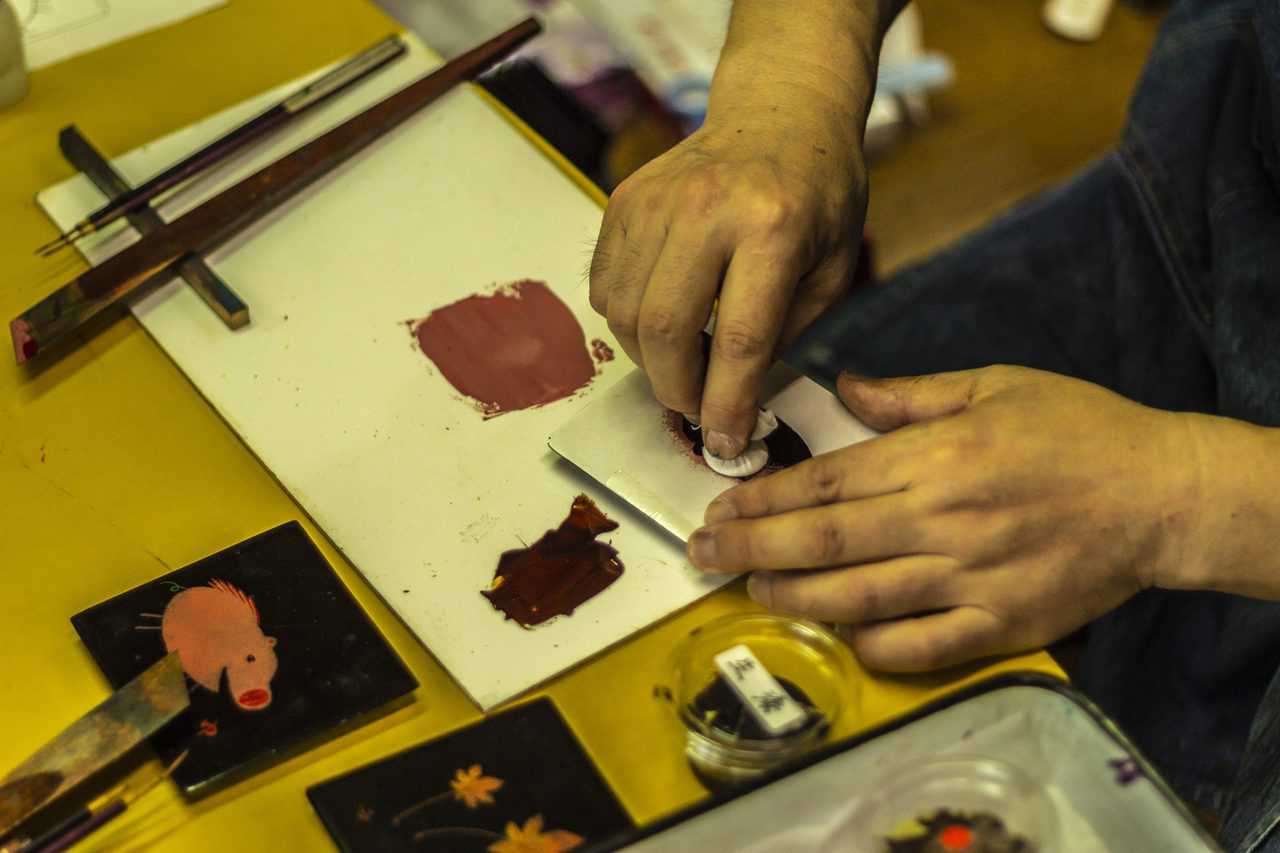 Farbe für traditionelle Lackwaren in Murakami wird angemischt.