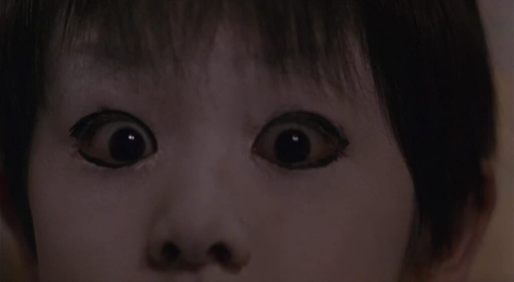 Szene aus Ju-On, geschockter Blick eines Kindes.