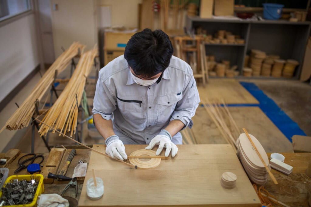 Ein Mann misst Holz in Aomori, Japan