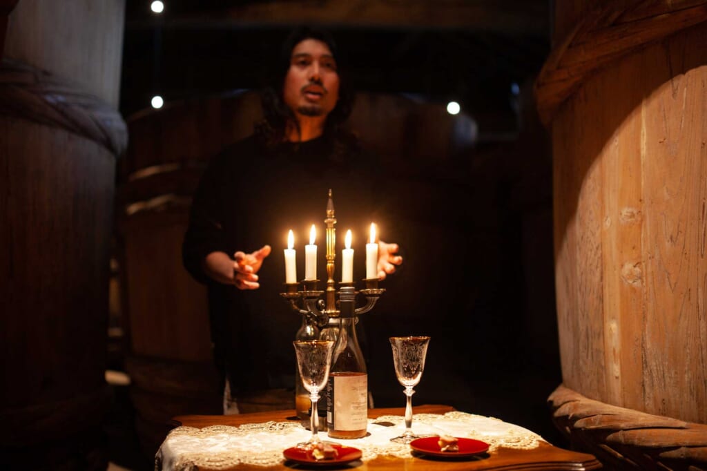 Ein Mann hinter Kerzen in einem dunklen Raum in Akita, Japan