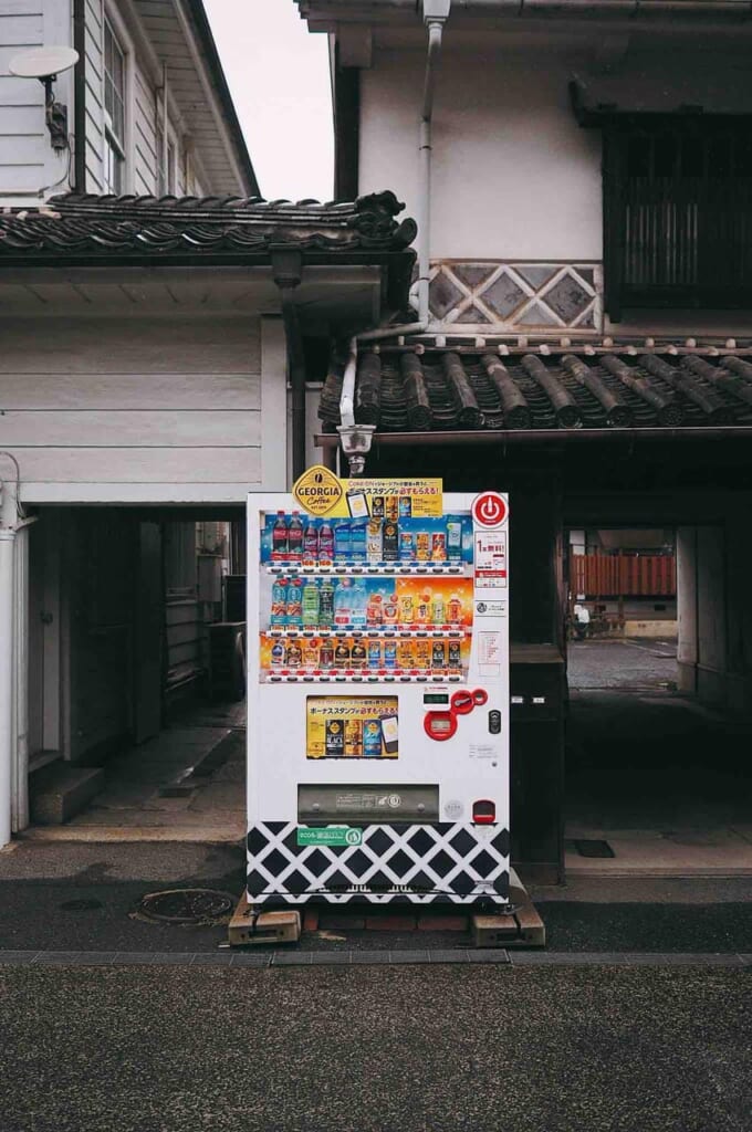 Verkaufsautomat in Japan vor einem traditionellen Haus