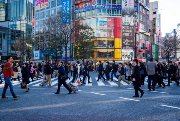 Personen überqueren eine Straße in Japan