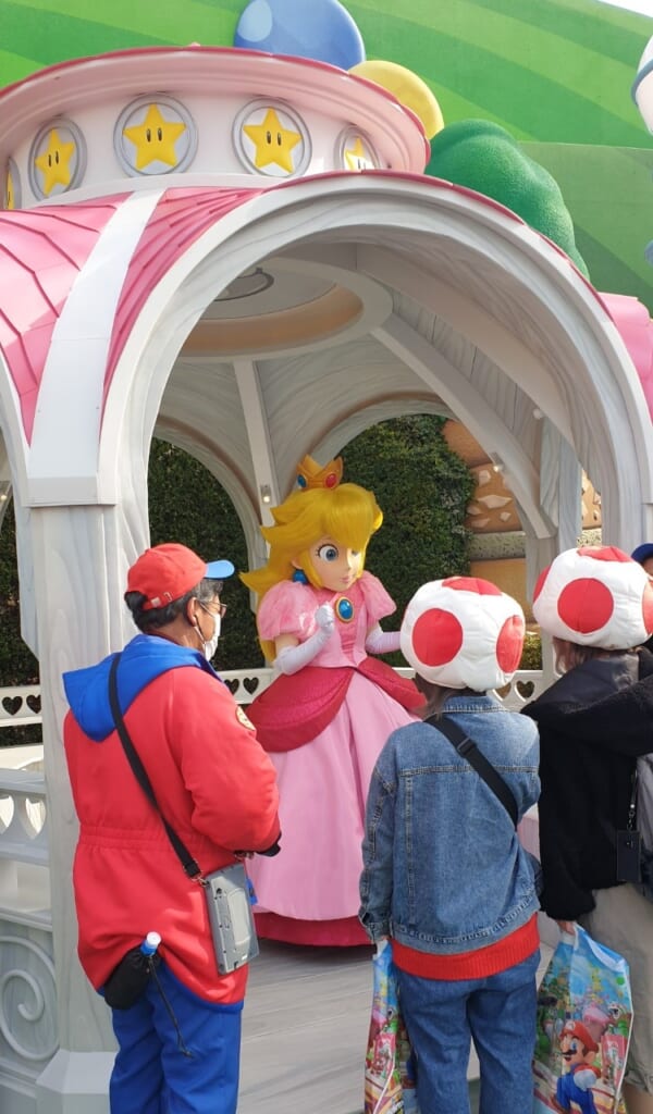 visitatori incontrano la Principessa Peach al Super Nintendo World