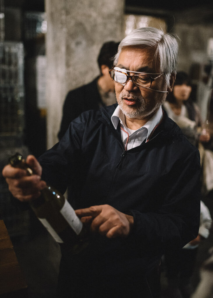 Esaminando una bottiglia di vino alla cantina Marufuji