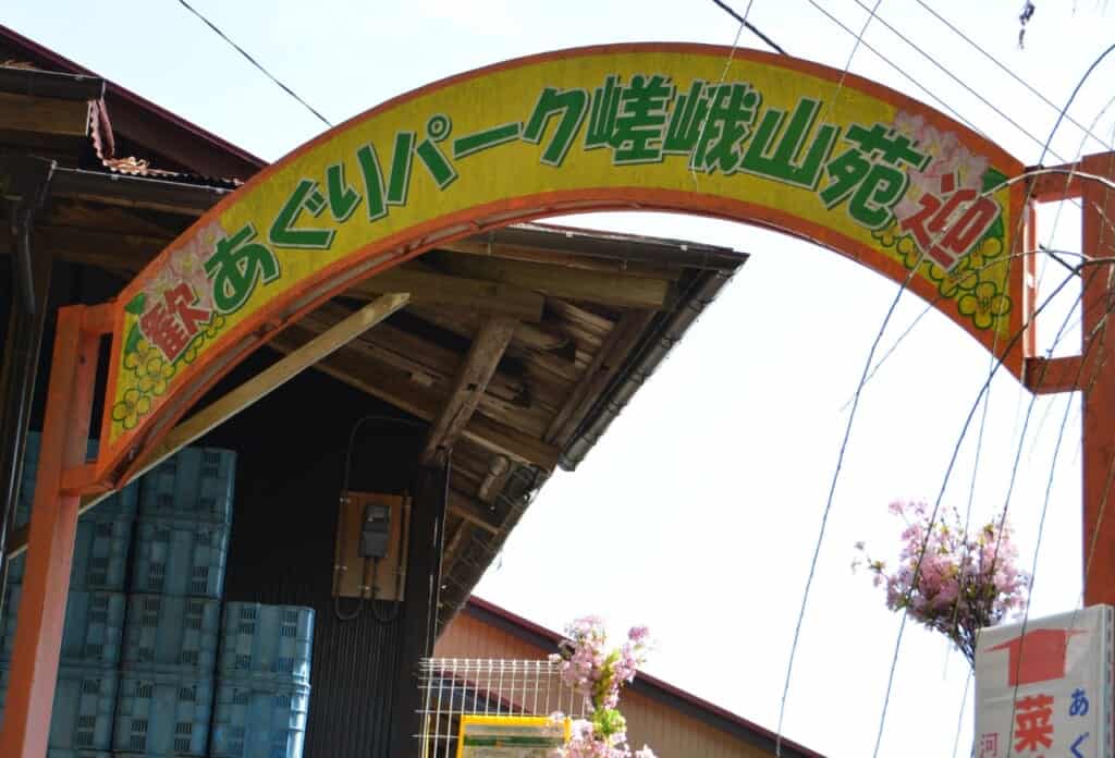Un cartello con scritte in giapponese che indica l'entrata del parco
