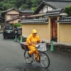 Donna in bicicletta vestita per ripararsi dalla pioggia