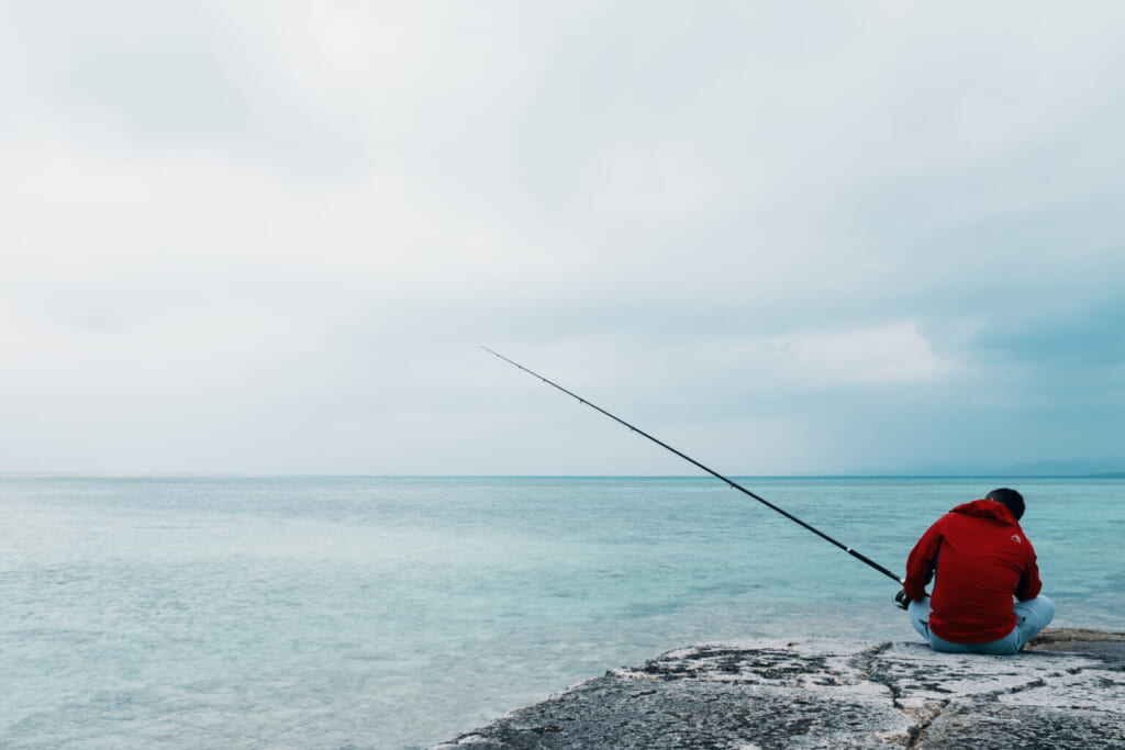 Uomo che pesca nel mare di Taketomi, Okinawa