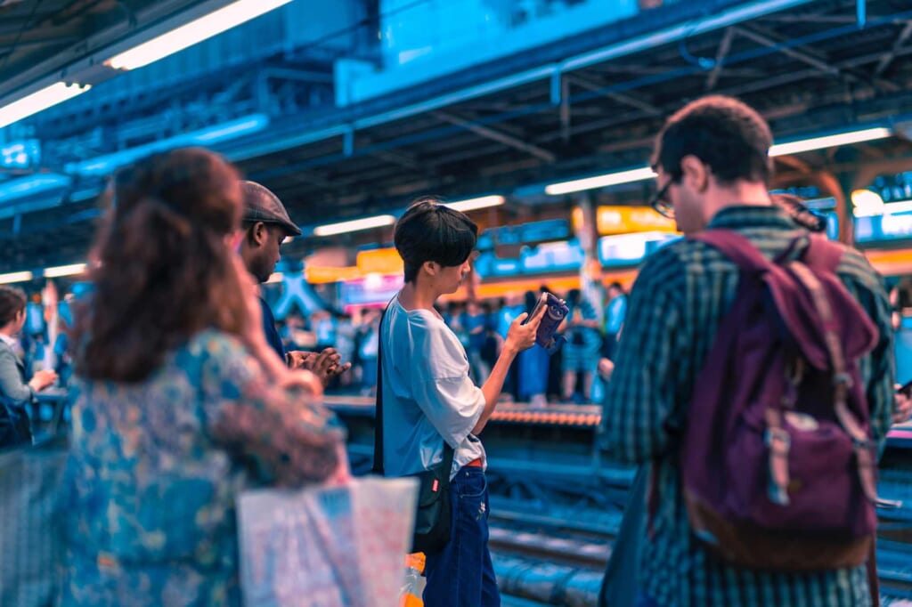 Passeggeri di varie nazionalità aspettano il treno in Giappone