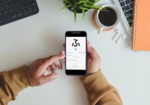Dettaglio di una persona sulla scrivania che usa una app per imparare l'alfabeto hiragana