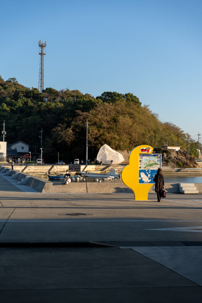 un visitatore al tramonto nel porto di Naoshima