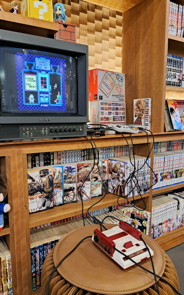 Console Nintendo e scaffali di manga in un hotel a Kyoto