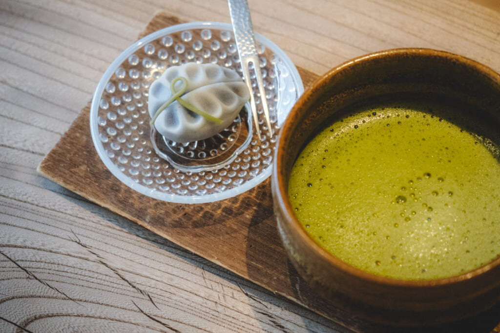 Tazza di tè matcha accompagnata da un wagashi